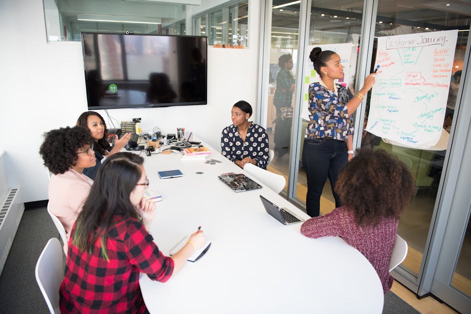 A multicultural office team engages in a collaborative brainstorming session around a conference table