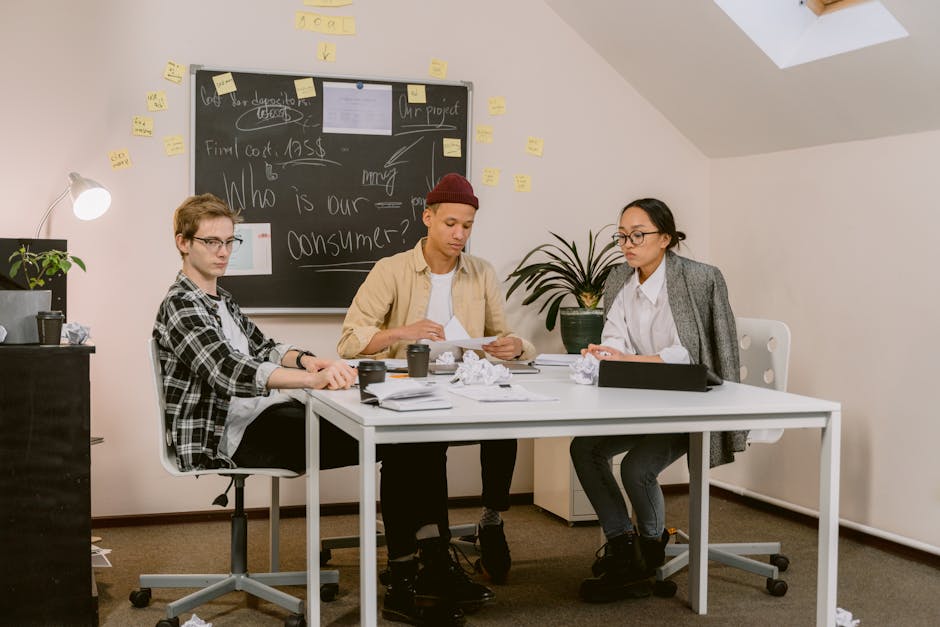 Group of diverse young adults brainstorming business ideas in a modern office.
